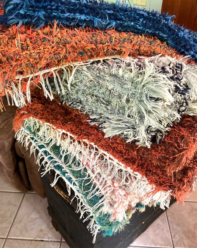 Colorful, handmade rugs piled on top of each other.